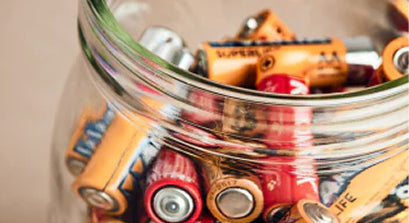 A glass jar full of dead batteries
